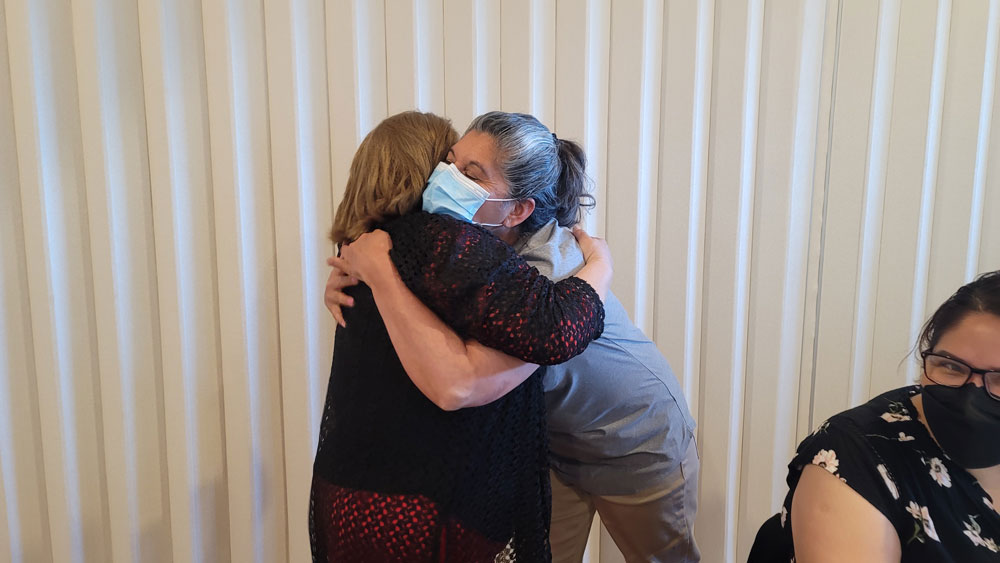 Two Encuentro community members sharing a hug